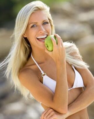 Ein Mädchen isst einen Apfel, um 10 kg pro Monat abzunehmen